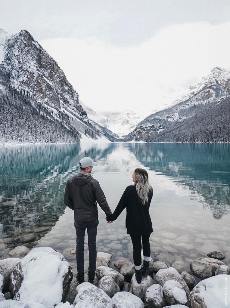 Couple looking out onto lake louise in alberta canada