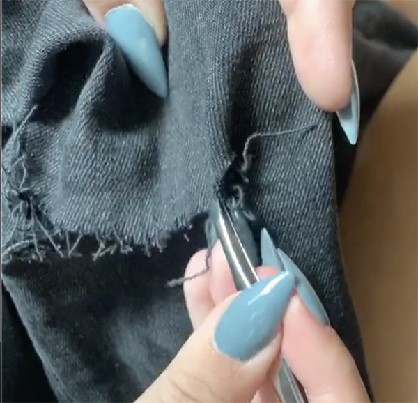 using tweezers to fray the edge and hem